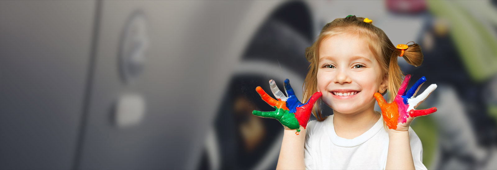 Une jeune fille montre ses mains recouvertes de peinture